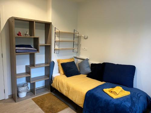 a small bedroom with a bed and a shelf at Les Cerisettes in Wavre