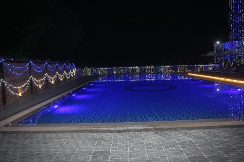 a swimming pool covered in blue lights at night at Brisa Marina CBC Resort ব্রিসা মেরিনা সিবিসি রিসোর্ট in Patenga