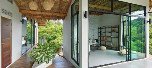 two views of a house with glass doors and a porch at Villa on the Rock - Luxury, Privacy, Pool, Sea View in Koh Phangan in Thong Sala
