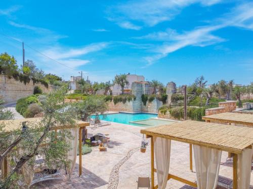 a backyard with a swimming pool and a wooden table at Cava Li Santi Residence in Nardò