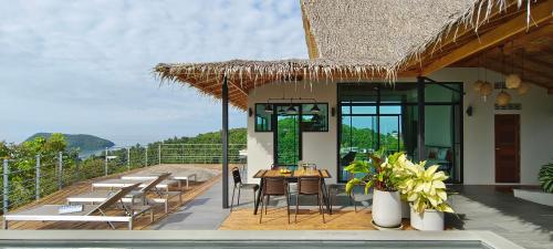 a restaurant with a table and chairs on a balcony at Villa on the Rock - Luxury, Privacy, Pool, Sea View in Koh Phangan in Thong Sala