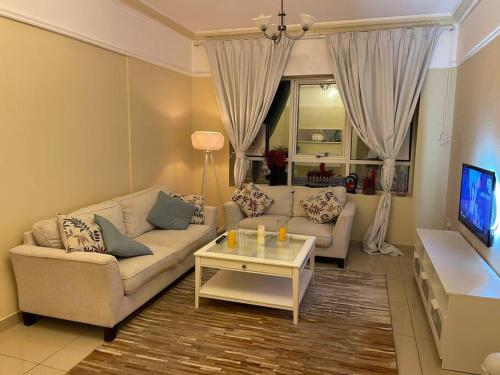 een woonkamer met een bank en een salontafel bij deluxe apartment closed to beach in Sharjah