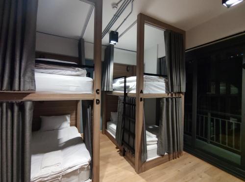 Pokój z 3 łóżkami piętrowymi i lustrem w obiekcie N5 Ratchawong Hostel w mieście Samphanthawong