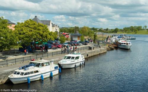 a group of boats docked at a dock on a river at Rowing club house in Carrick on Shannon