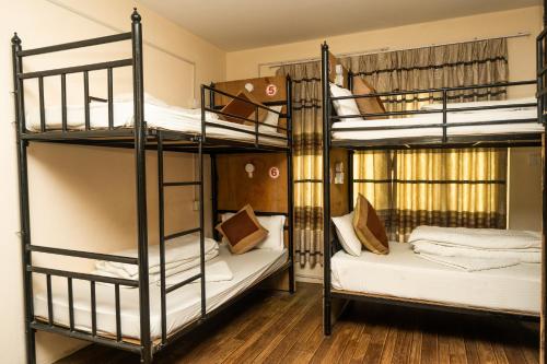 two bunk beds in a room with wooden floors at Kathmandu Peace Hotel in Kathmandu