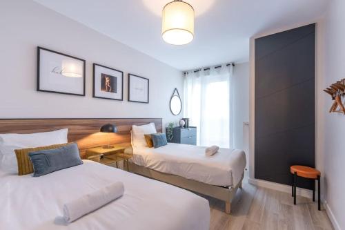 a hotel room with two beds and a window at *New* Céleste Appart 6 Pax 5 min Disney in Serris