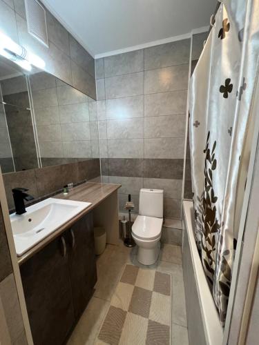 een badkamer met een wastafel, een toilet en een bad bij Nurly Zhol apartment in Promyshlennyy