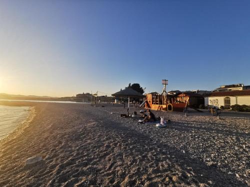 a group of people sitting on a beach at Mobilehome Mali No 2 in Pakoštane