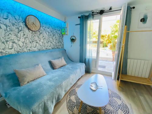 - un canapé bleu dans une chambre avec une table dans l'établissement Charmant studio à Talence, à Talence