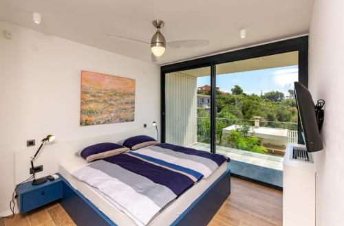 - une chambre avec un lit et une grande fenêtre dans l'établissement Luxury villa Mar with infinity pool in Rab, à Palit