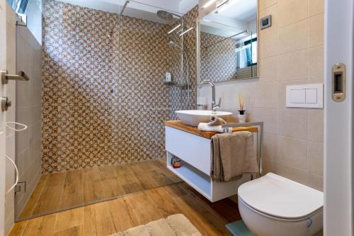 a bathroom with a toilet and a sink and a shower at Luxury villa Mar with infinity pool in Rab in Palit
