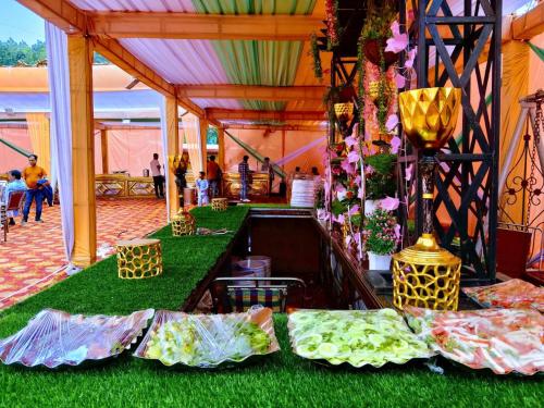 namiot ze stołem z zieloną trawą i kwiatami w obiekcie DAMYANTI RESORT w mieście Bhimtal