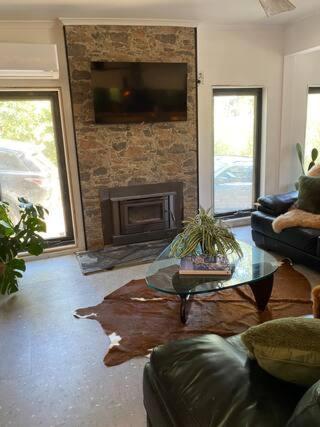 sala de estar con mesa y chimenea en Sul Lago - Lakefront Family Friendly home, en Jamieson