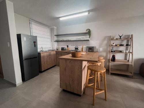 Coogee Bay Apartments في غونوبي: مطبخ مع ثلاجة وطاولة وكراسي
