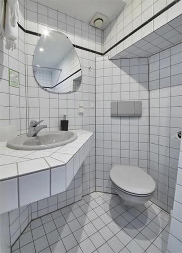 a bathroom with a toilet and a sink and a mirror at Gästehaus Zur Traube in Reil