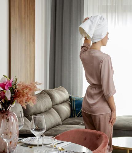a woman wearing a chefs hat standing in a living room at Supernova Royal Residence in Novi Sad
