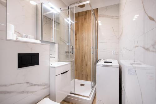 華沙的住宿－Labo Apartment Niepodległości，带淋浴和卫生间的白色浴室