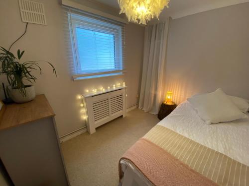 a bedroom with a bed and a window with lights at Leeward Lodge in Totland