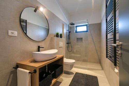 a bathroom with a sink and a mirror at Modern villa Amoroso with pool in Porec in Nova Vas