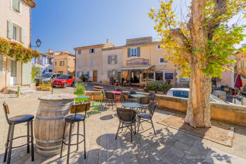 a group of chairs and tables and a tree on a street at Bar des Amis in Villars