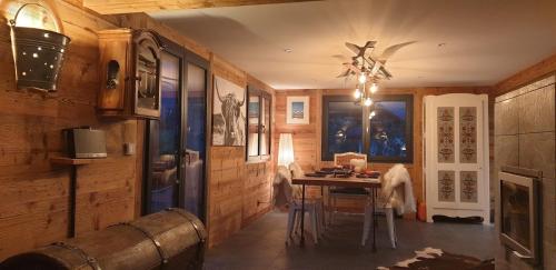 a dining room with a table and a ceiling fan at Chalet le Grenier des Crosets, Vue exceptionnelle sur les Dents du Midi in Champéry