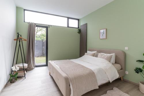 Un dormitorio con una cama grande y una ventana en Hike & Bike Home en Heusden - Zolder