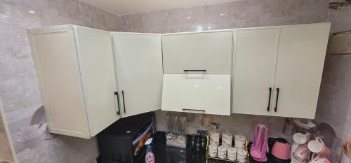 a kitchen with white cabinets and some shoes at Socota real estate development in Cairo
