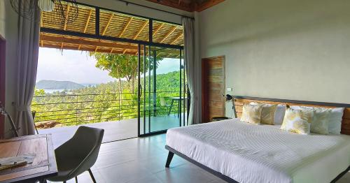 een slaapkamer met een bed en een groot raam bij Wao Villa Duo - Infinity Pool - Seaview - Garden in Thongsala