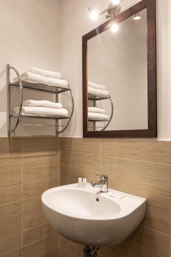 a bathroom with a sink and a mirror and towels at Fleming Suites by Hili in Rome