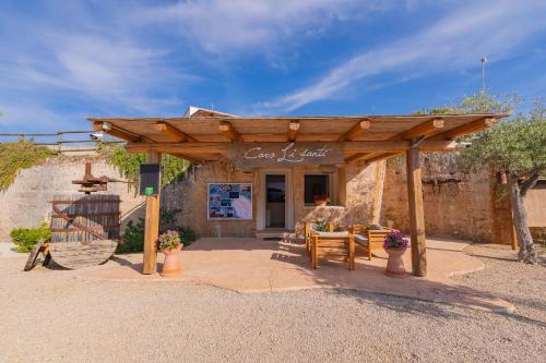 a wooden pergola in front of a building at Cava Li Santi Residence in Nardò