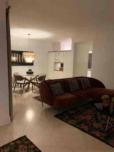 a living room with a brown couch and a table at Estoril Terrace in Estoril