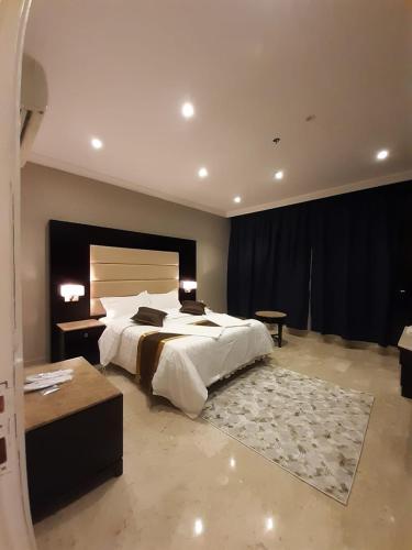 una camera con un grande letto bianco e un tappeto di لوريت للشقق المخدومة a Gedda