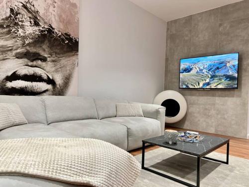 uma sala de estar com um sofá e uma fotografia na parede em BS Apartment 2 em Durrës