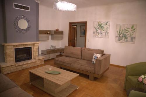 een woonkamer met een bank en een open haard bij Kouros Kalamitsa in Kavala