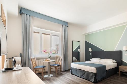 a hotel room with a bed and a table at Fleming Suites by Hili in Rome