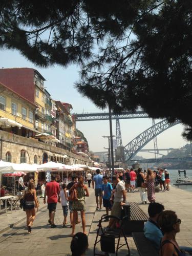 a crowd of people walking on a sidewalk near a bridge at Residencial clérigos ROOM 3 in Porto