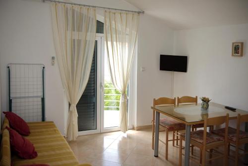 a living room with a dining room table and a television at Villa Srima in Vodice