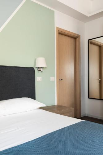 a bedroom with a white bed and a mirror at Fleming Suites by Hili in Rome