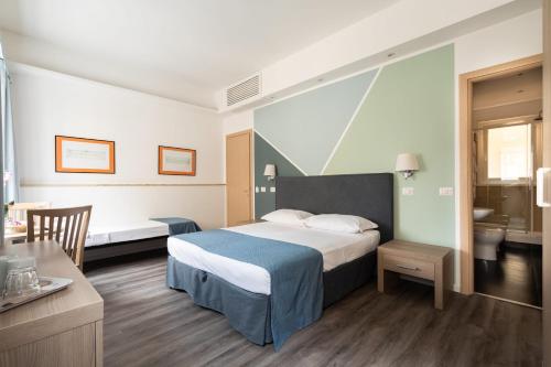 ローマにあるフレミング スイートのベッドとバスルーム付きのホテルルームです。