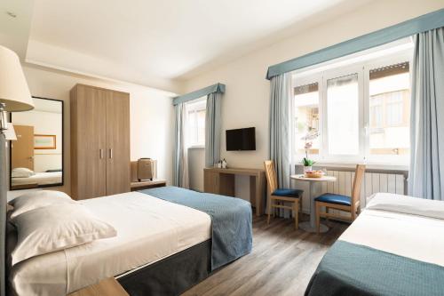 a hotel room with two beds and a table at Fleming Suites by Hili in Rome