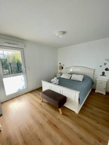 une chambre blanche avec un lit et une fenêtre dans l'établissement La Roseraie Toulousaine avec parking privé, à Toulouse