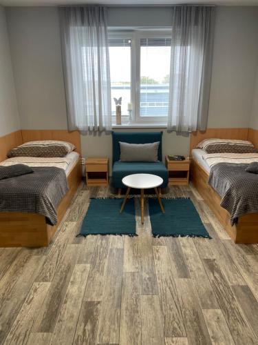 a bedroom with two beds and a table and a chair at Apartmány Andělská in Olomouc