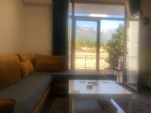 sala de estar con sofá, mesa y ventana en Smart Lugano Apartment, en Tirana