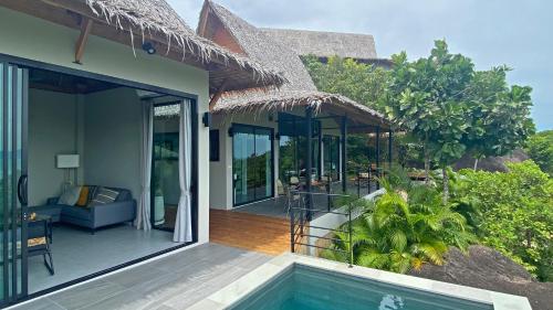 een huis met een balkon en een zwembad bij Wao Villa Duo - Infinity Pool - Seaview - Garden in Thongsala