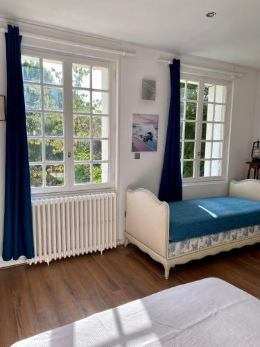Cette chambre comprend un lit et deux fenêtres. dans l'établissement Maison Voltaire, à Bonsecours