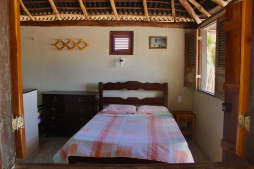 1 dormitorio con 1 cama, vestidor y ventana en Chalés Ventos de Amarração, en Ponta do Anel