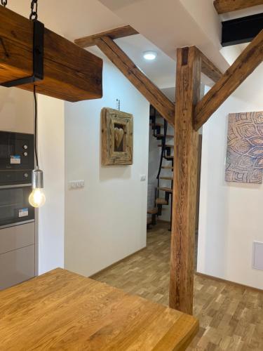 a kitchen with wooden beams and a staircase in the background at Apartmány Marienhof in Znojmo