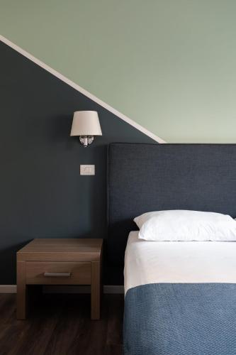 a bedroom with a bed and a table with a lamp at Fleming Suites by Hili in Rome