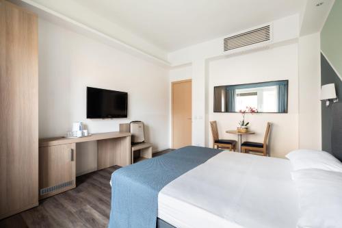 Cette chambre d'hôtel dispose d'un lit et d'une table avec une télévision. dans l'établissement Fleming Suites, à Rome