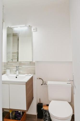 une salle de bain blanche avec des toilettes et un lavabo dans l'établissement 2 pièces de charme au coeur du village de CABRIS, à Cabris
